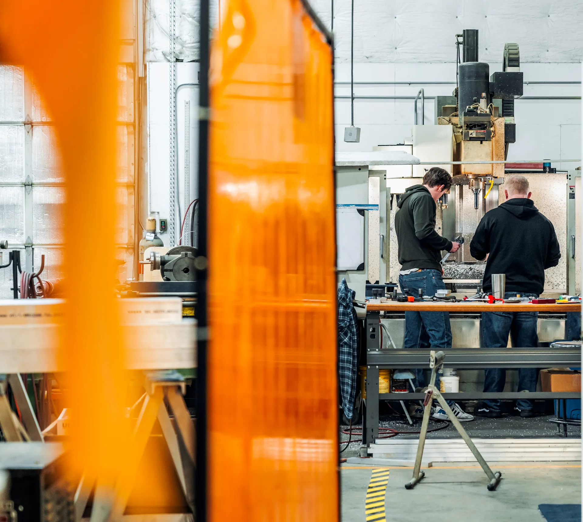 Two colleagues working together at a machine in the Allflight workshop