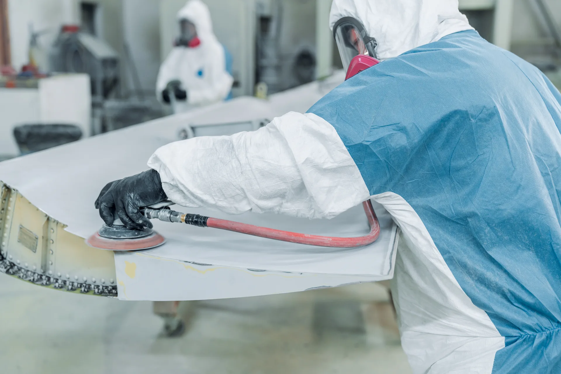 Allflight technician sanding the surface of an aircraft component